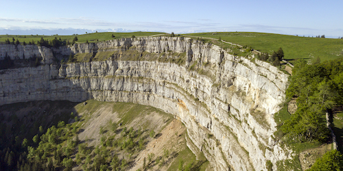 The World Trail Majors - a large canyon dropping away below the camera, with grassy slopes at the top of the cliff