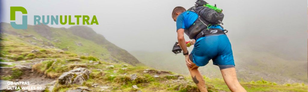 Running into Trouble and out of Injury; a man striding up a grassy mountain slope in thick cloud
