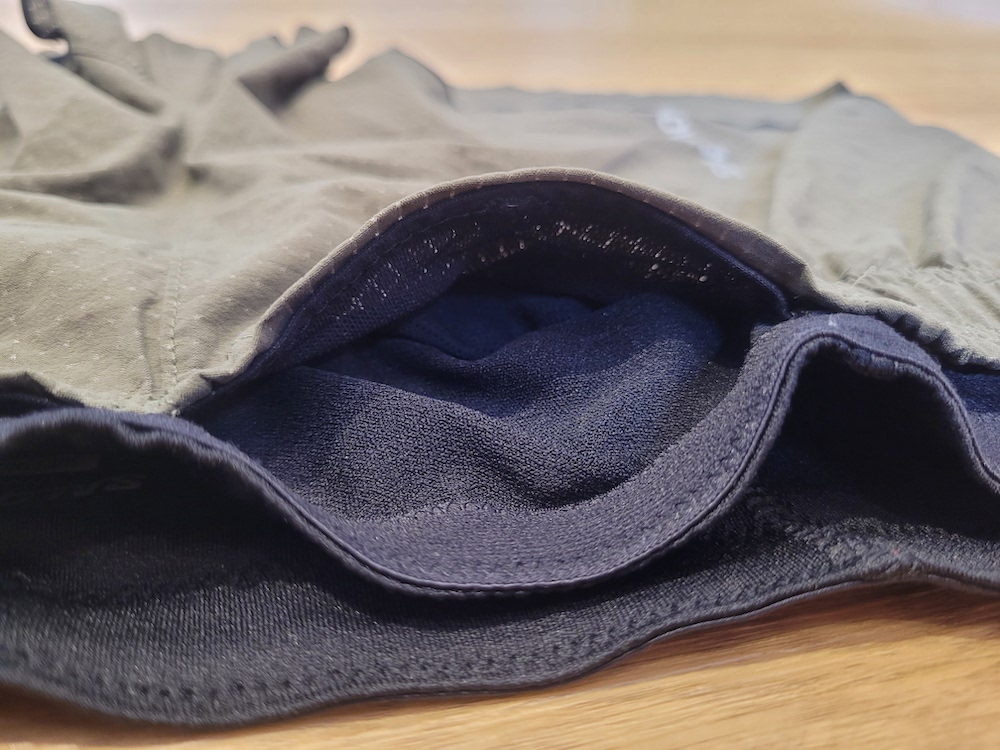 Salomon Sense Aero 3" Shorts Review a pair of brown shorts laid out on a wooden table so that you can see the detail of the fabric and a hidden pocket